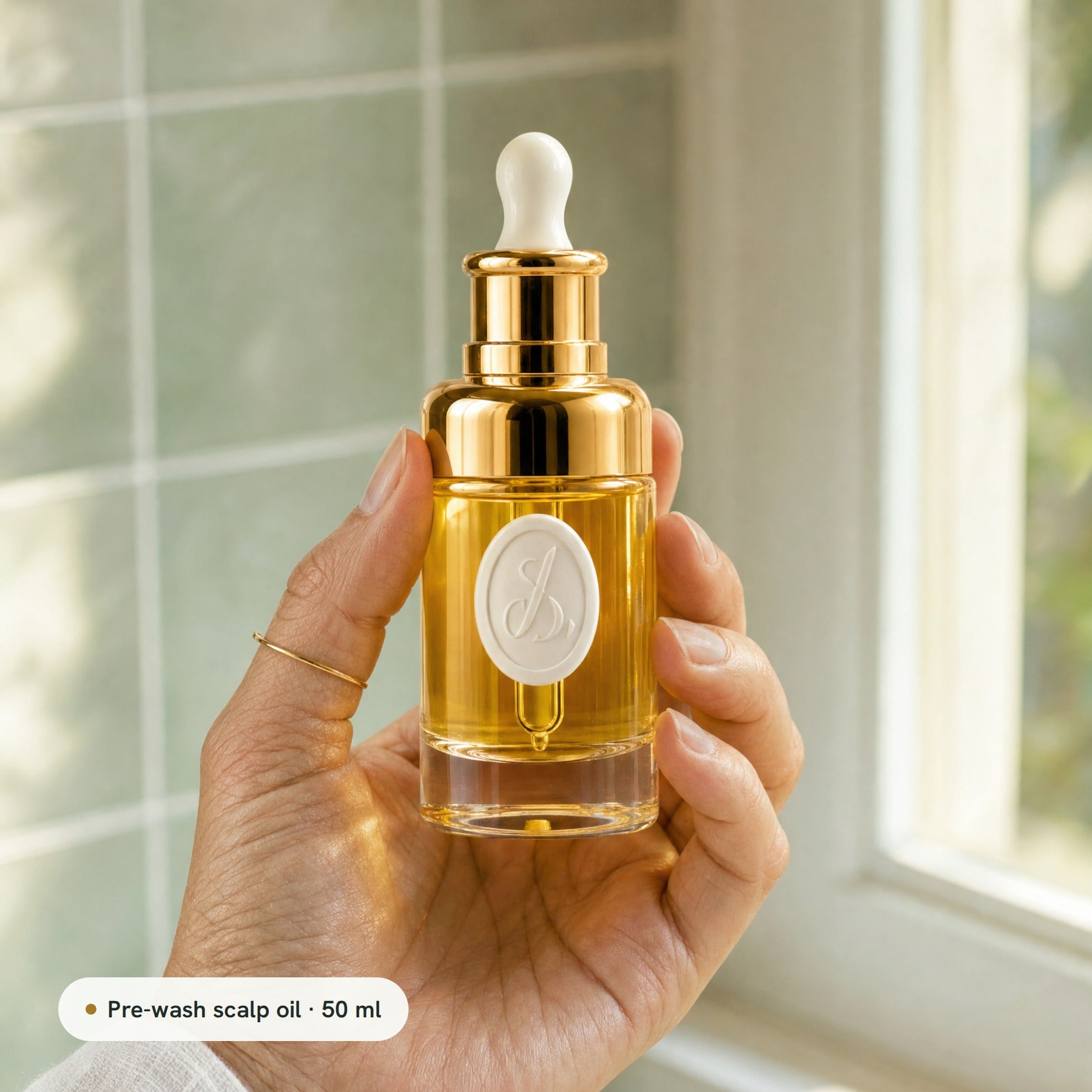 The 50 ml Lumina Oil bottle held in a hand